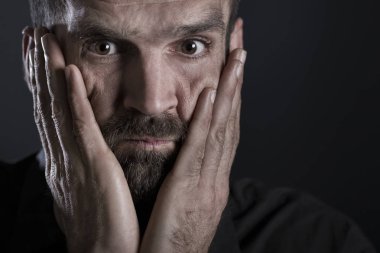 Endişeli adam facepaling yakın.