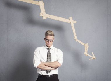 Olumsuz trend ile grafik önünde hoşnutsuz işadamı.