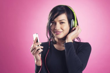 Kulaklıkla müzik dinleyen mutlu bir kız..