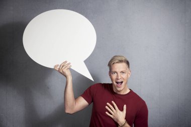 Boş konuşma balonu tutan neşeli adam.