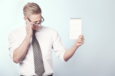 Boş deftere bakan sevimli işadamı.