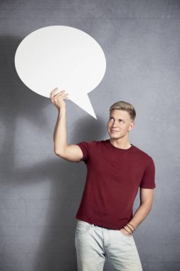 Boş konuşma balonuna bakan gülümseyen adam. 