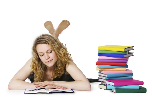 Girl lying on floor and reading, looking at book — Stockfoto