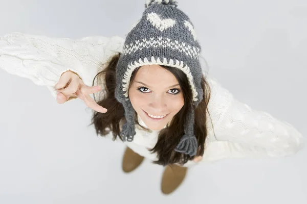 Nettes Mädchen in warmer Winterkleidung macht Siegeszeichen. — Stockfoto