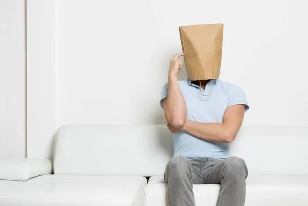 Homem anônimo sentado no sofá e pensando . — Fotografia de Stock