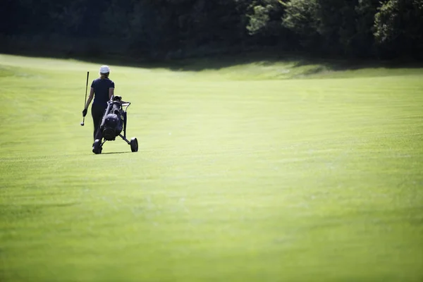 가방을 들고 페어 웨이를 걷는 골프 선수. — 스톡 사진