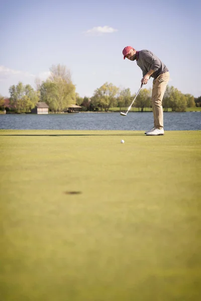 Mężczyzna golf gracz wprowadzenie na zielony. — Zdjęcie stockowe