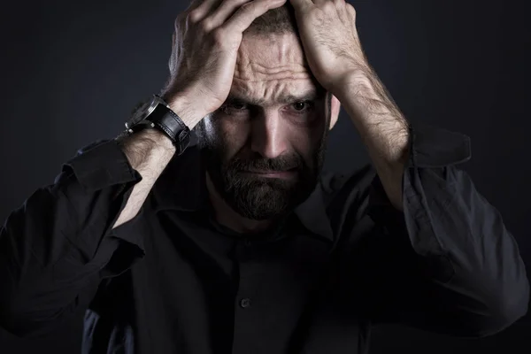 Alnında ellerle endişeli görünen yoksul adam..