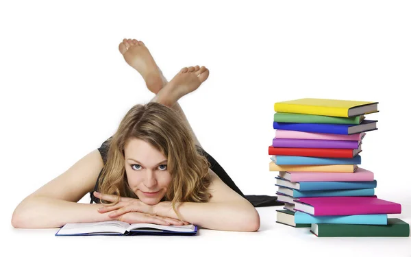 Chica acostada en el suelo y leyendo, mirando a la cámara — Foto de Stock