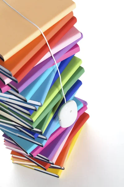 Mus hängande från toppen av flerfärgade bok stacken — Stockfoto