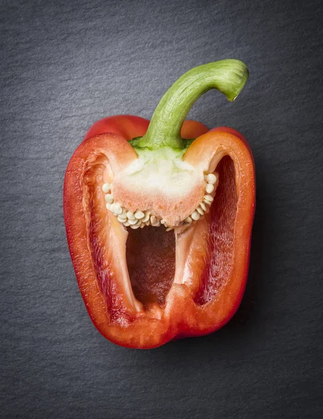 Red cut sweet pepper half on stone. — Stock Photo, Image