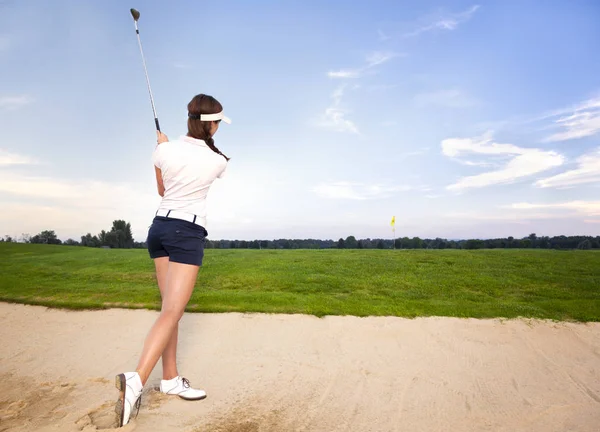Lány golfjátékos bunkerben Chipping labda. — Stock Fotó
