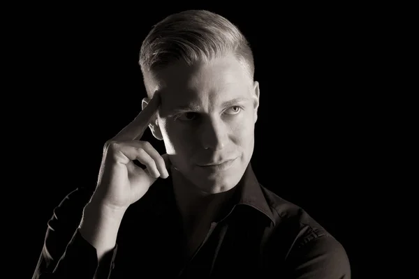 Low key portrait of attractive man looking up, black and white.