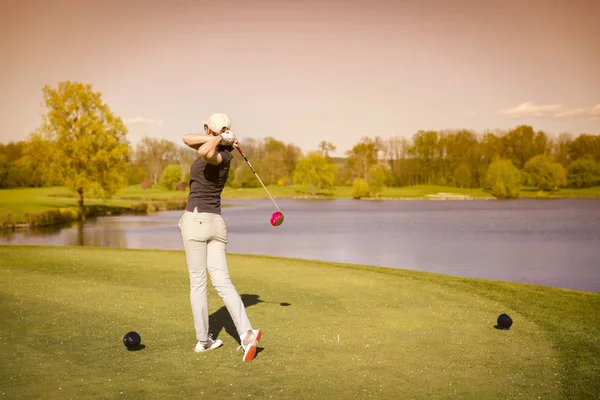 Jogadora de golfe feminino teeing off . — Fotografia de Stock