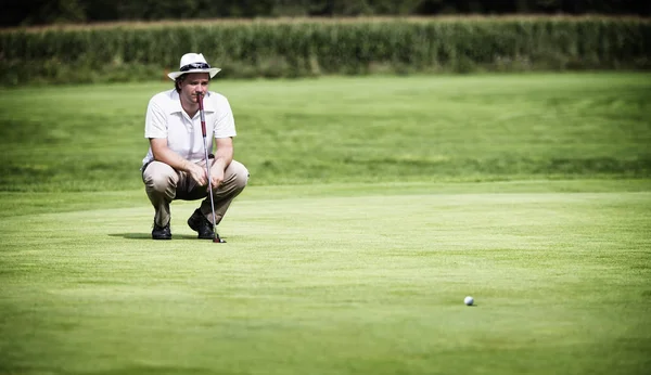 Golfçü koymadan önce yeşili analiz ediyor. — Stok fotoğraf