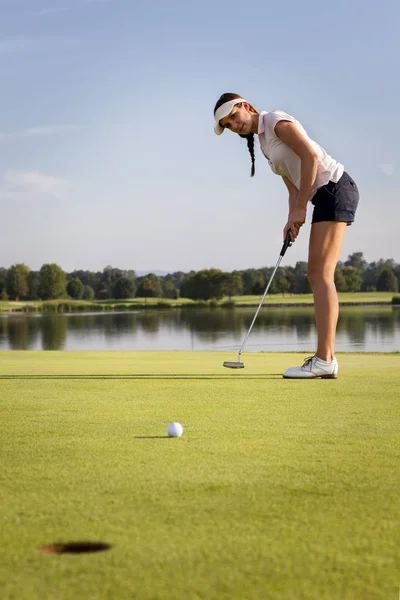 Menina golfista colocando bola no verde . — Fotografia de Stock