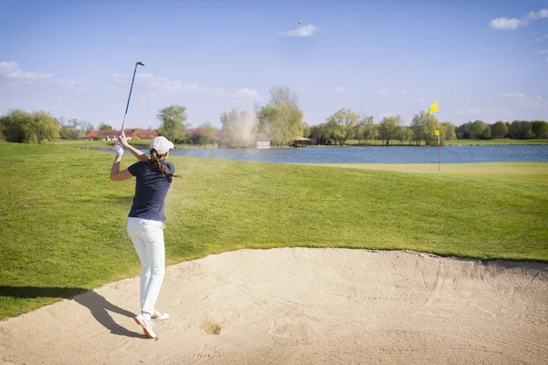 Golfspeler pitching vanuit bunker. — Stockfoto