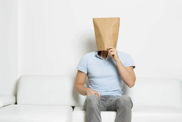 Hombre pensante con la cara cubierta sentado en el sofá . —  Fotos de Stock