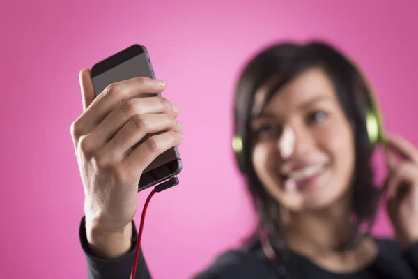 Joyful girl listening to music with earphones and m3p player.