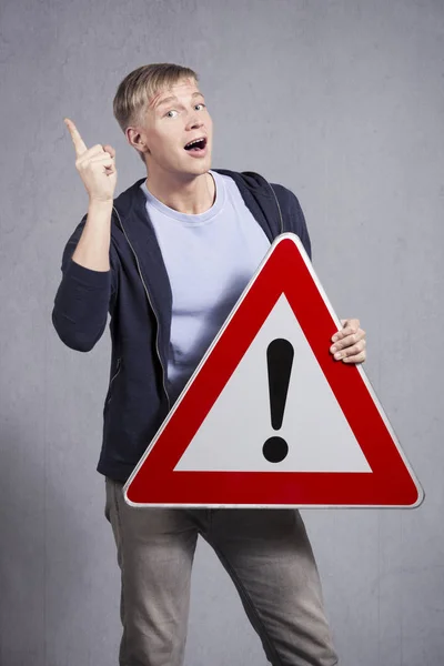 Man holding warning road sign with exclamation mark. — Stock Photo, Image