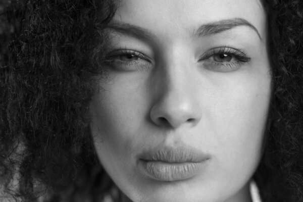 Black and white portrait of a beautiful woman frowning and looking upset.