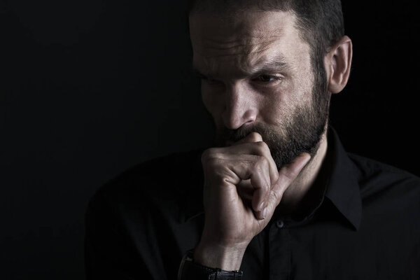 Задумчивый человек выглядит серьезным и хмурым.
.