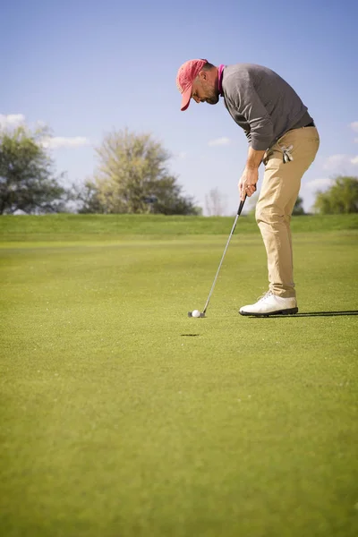 Manliga golfspelare att sätta på grön. — Stockfoto