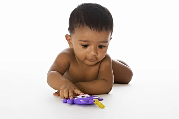 Süßes indisches Baby spielt auf dem Boden Stockbild