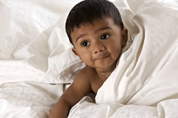 Schönes indisches Baby auf Decke liegend lizenzfreie Stockbilder