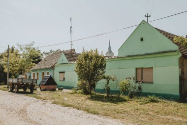 Sırbistan 'ın Bela Cerkva yakınlarındaki eko Selo adlı Sırp köyünde yeşil kırsal binalı eski bir çakıl sokak manzarasına, güneşli yaz günü Banat adı verildi.