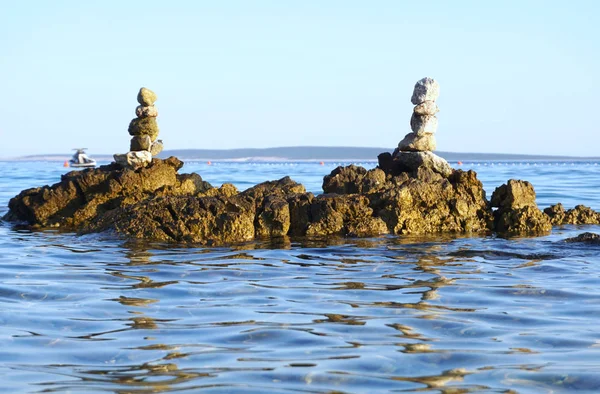 Vista de la costa desde tierra, con rocas apiladas en el agua — Foto de Stock