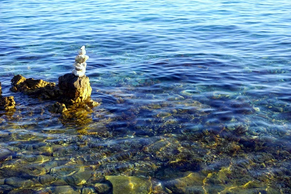 澄んだ青い海の水に積み重ねられた白い石 — ストック写真