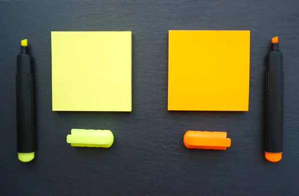 Αυτοκόλλητες σημειώσεις σε κίτρινο και πορτοκαλί χρώμα με μαρκαδόρους στο ίδιο χρώμα στο μαύρο φόντο του πίνακα — Φωτογραφία Αρχείου