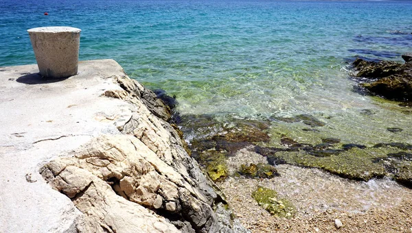 Natureza fundo com detalhes da costa do mar e praia de seixos selvagens e pedra amarração bollard — Fotografia de Stock