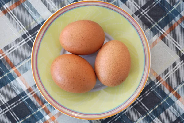 Куриные яйца на маленькой тарелке. Сырые и свежие органические продукты на небольшой тарелке — стоковое фото