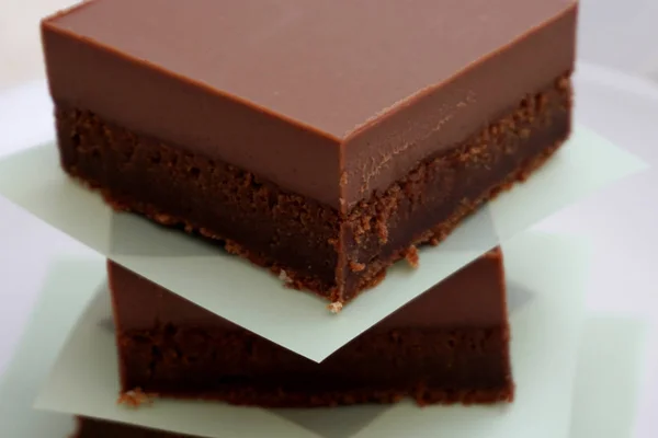 Kusy domácích zdravých koláčů z kakaa s bohatou smetanovou glazou z mléčné čokolády bez lepku — Stock fotografie