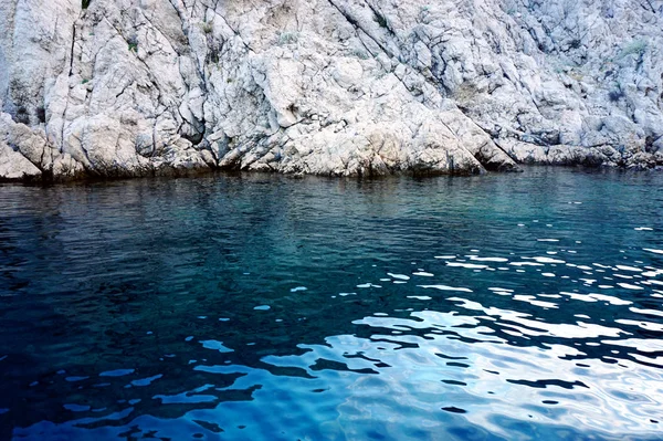 石の壁のような大きな海の石、青い海の水に浸漬 — ストック写真
