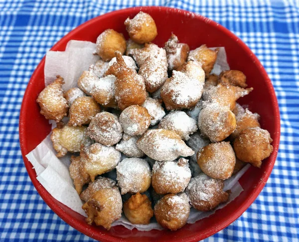 Kom vol met zelfgemaakte beignets in poedervorm met ijssuiker op de Vintage keuken schotel handdoek — Stockfoto