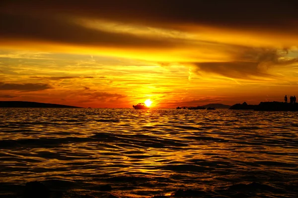 Dramatische rode en oranje hemel bij zonsondergang, schemering natuur achtergrond met silhouet van boten en mensen — Stockfoto