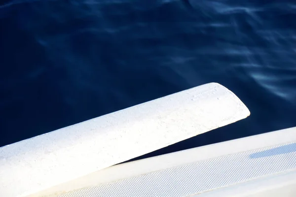 Κορυφή ενός ξύλινου λευκού κουπί σε ένα πλοίο πάνω από τη γαλάζια θάλασσα — Φωτογραφία Αρχείου