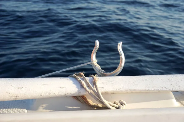 Bordázott oarlocks a fehér fa lapát régi kötél kötötte körül, és a kék víz háttér — Stock Fotó