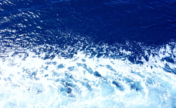 Acqua di mare increspata con inchiostro tono di colore blu e schiuma di mare bianco, vista dall'alto — Foto Stock