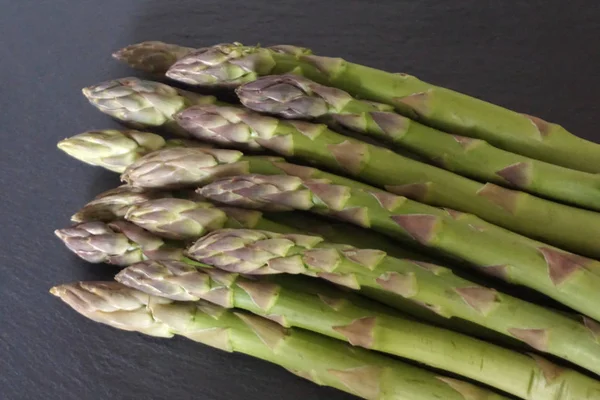 Mazzo di asparagi freschi verdi, biologici e naturali su fondo nero — Foto Stock