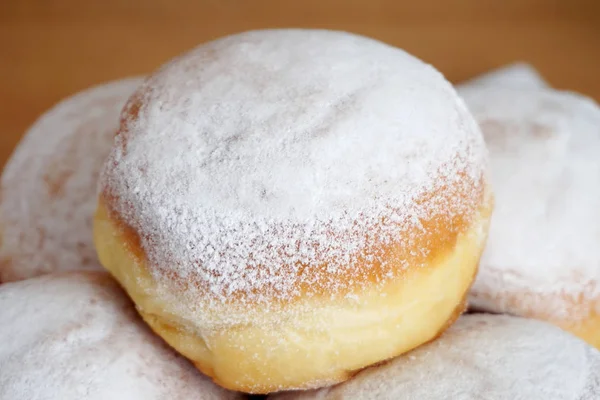 Zoete dessert met poeder witte suiker. Bord met lekkere donuts met één op de top — Stockfoto