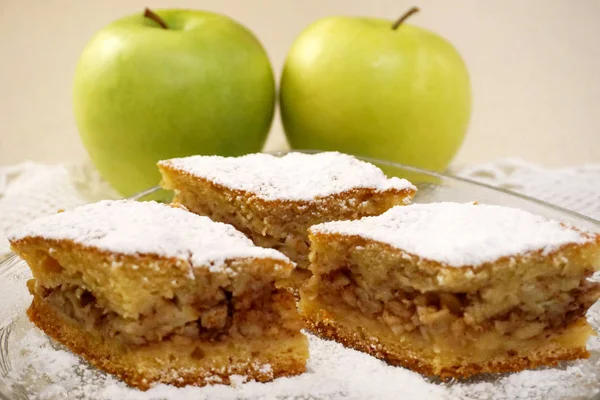 Drei Stück hausgemachter traditioneller Apfelkuchen mit zwei grünen Bio-Äpfeln im Hintergrund — Stockfoto