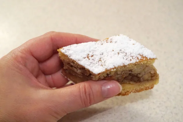 Vrouw hand met stuk van zelfgemaakte smakelijke biscuit cake — Stockfoto