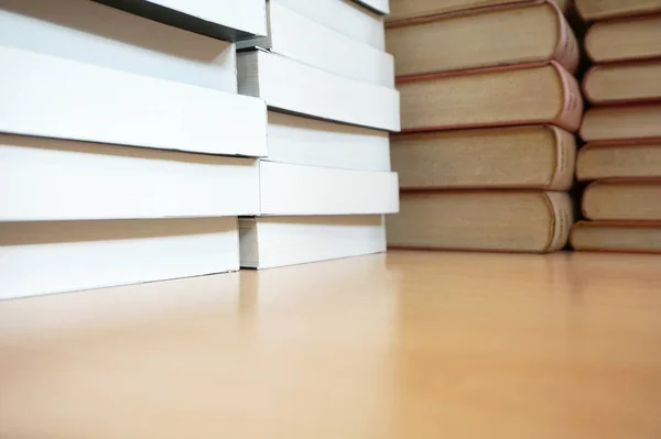 Livros antigos e novos livros empilhados na mesa de madeira — Fotografia de Stock