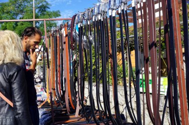 Panayırdaki pazar satışlarında çeşitli deri kemerlere bakan bir çift.