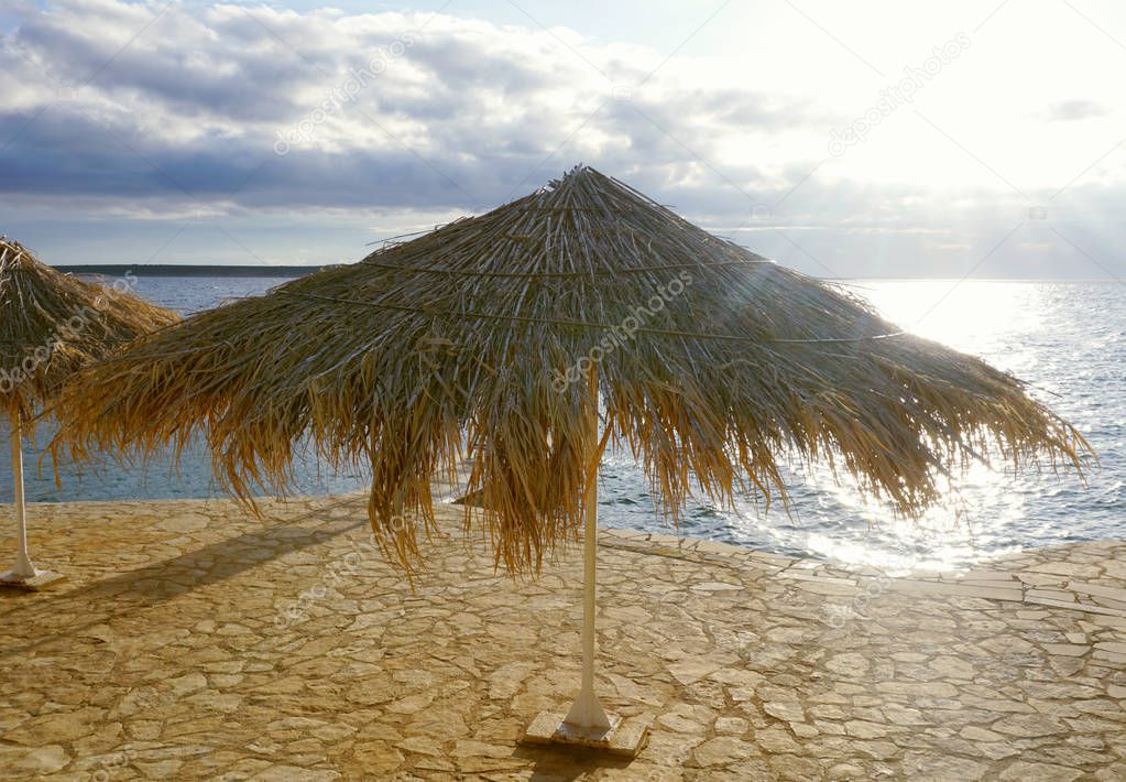 Parasol made from dry leaves in sea sunset