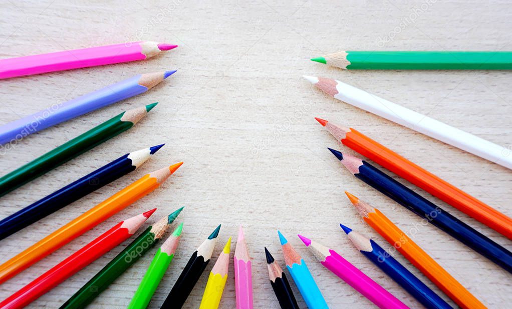 Crayon, wooden pencils in different color on the natural wood background